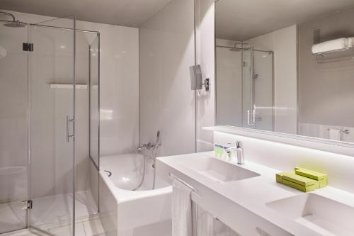 a bathroom with a sink and a shower and a toilet at Hotel Silken Palacio Uribarren in Lekeitio