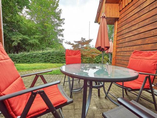 a patio with a table and chairs and an umbrella at Strandschlösschen Sellin - Haushälfte 2 in Ostseebad Sellin
