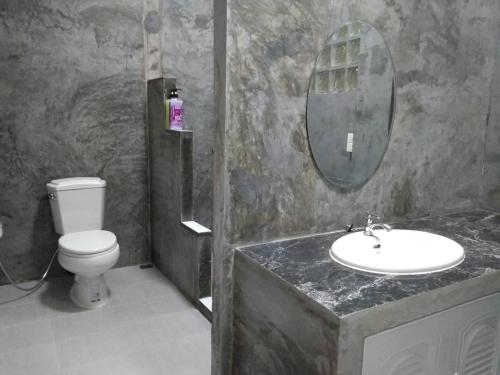a bathroom with a sink and a toilet and a mirror at Tk Home 1 in Lampang
