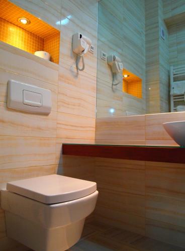 a bathroom with a toilet and a sink at Hotel Tim's in Skopje