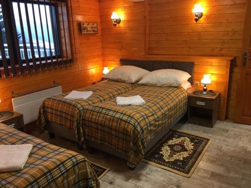1 Schlafzimmer mit 2 Betten in einem Zimmer mit Holzwänden in der Unterkunft Stacja Narciarska SOSZÓW Wisła in Wisła