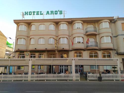 un grand bâtiment avec un panneau en haut dans l'établissement Hotel Aro'S, à Casas Ibáñez