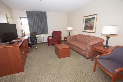 a living room with a couch and a tv at La Quinta Inn by Wyndham Detroit Southgate in Southgate