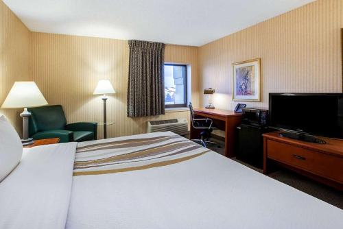 a hotel room with a bed and a flat screen tv at La Quinta Inn by Wyndham Detroit Southgate in Southgate