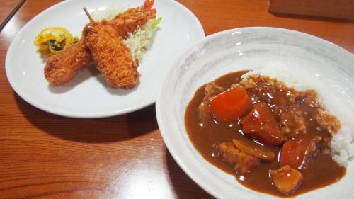 two plates of food with meat and rice on a table at 旅館いしのまき in Ishinomaki
