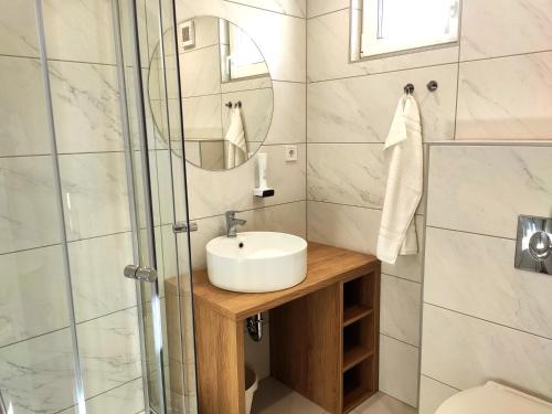 a bathroom with a sink and a shower at Ugo Apartman in Halászi