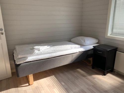 a small bed in a room with a night stand at Garsnes Brygge in Sjøvegan