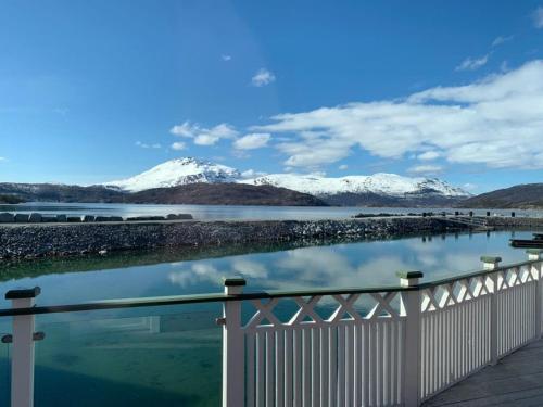 a view of a body of water with snow covered mountains at Garsnes Brygge in Sjøvegan