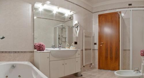 a bathroom with a tub and a sink and a bath tub at Hotel Spresiano in Spresiano