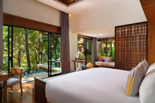 Avani Ao Nang Cliff Krabi Resort في شاطيء آونانغ: غرفة نوم بسرير كبير ونافذة كبيرة