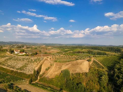 an aerial view of a farm with fields and trees at AGRiCAMPiNG POGGiO Ai PiNi WiNE CAMPiNG in Certaldo