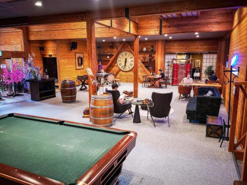 a room with a pool table and a large clock at Wadano Gateway Suites & Apartments in Hakuba