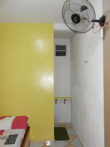 a room with a yellow wall and a fan at Pousada Salmo 23 in Algodoal