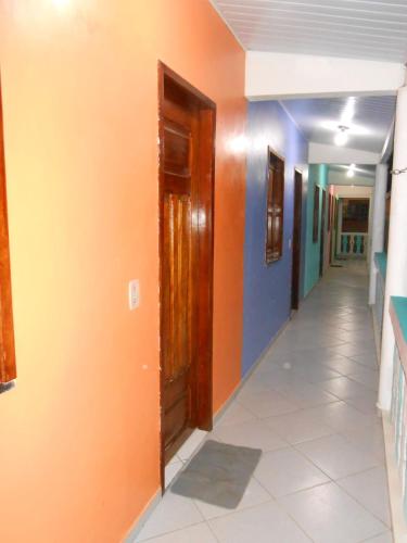 a hallway with orange and blue walls and a door at Pousada Salmo 23 in Algodoal