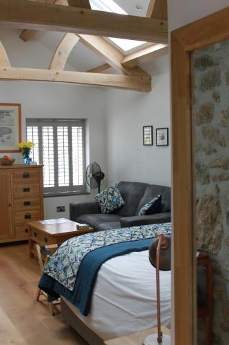 Paul的住宿－Bryher Cottage，一间卧室配有一张床和一张沙发