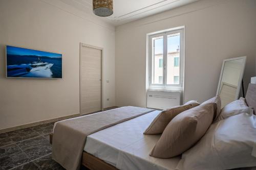 Un dormitorio con una cama grande y una ventana. en Riviera Rooms, en Alghero