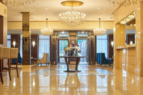a lobby with a table with flowers and chandeliers at City Holiday Resort & SPA in Kyiv