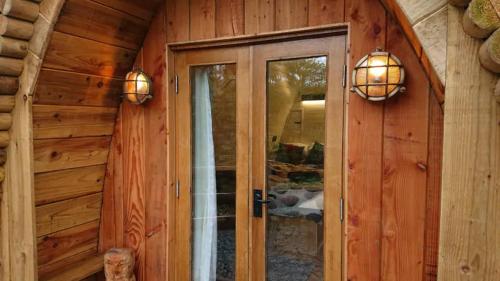 ドルゲラウにあるOwl Hut Cosy Ensuite Pod Snowdonia Coast Sleeps 2のログキャビン内のドア付きの部屋