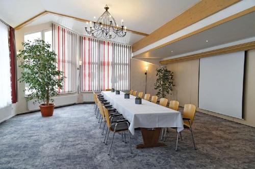 una grande sala conferenze con un lungo tavolo e sedie di Trip Inn Landhotel Krone a Roggenbeuren