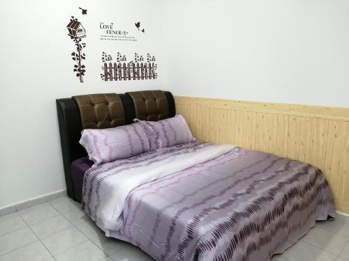 a bed with a black and white comforter in a room at SKYHOMESTAY TELOK PANGLIMA GARANG in Teluk Panglima Garang