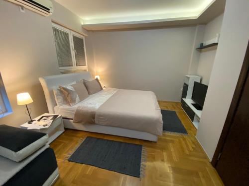 1 dormitorio con 1 cama blanca grande y 1 sofá en Studio SM Kragujevac, en Kragujevac