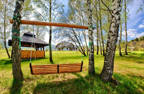 une balançoire suspendue à deux arbres dans un parc dans l'établissement CHATA NA KOŃCU ŚWIATA, à Wetlina
