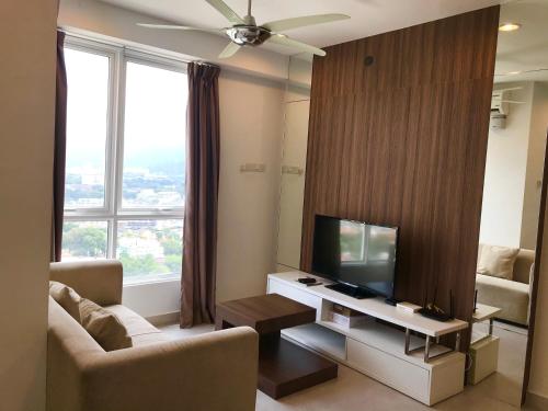 a living room with a flat screen tv and a couch at Mansion One Suites by Little Cabin in George Town