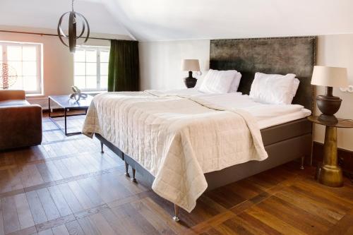 a bedroom with a large bed with a blanket on it at Hotell Visby Börs in Visby