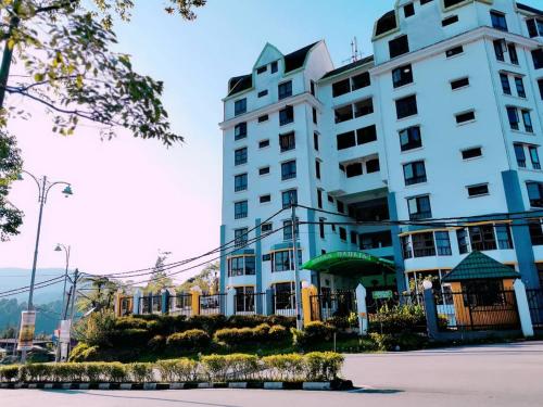 a large white building next to a street at My Home Apartment - Villa Dahlia Apartment in Cameron Highlands