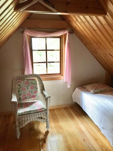 a bedroom with a chair and a window at Yngsjö, Aspvägen in Yngsjö