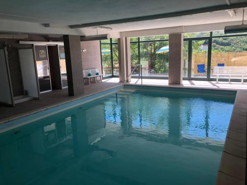 a swimming pool with blue water in a building at Hotel Campo Felice in Lucoli Alto
