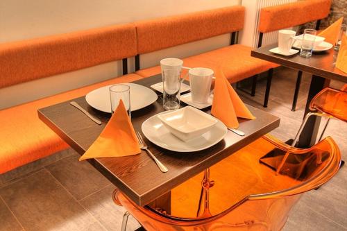 a wooden table with plates and utensils on it at Hotel Svambersky dum in Český Krumlov
