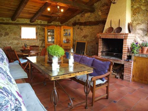 a living room with a table and a fireplace at Agroturismo El Mirador de la Cigüeña in Cabanillas del Monte