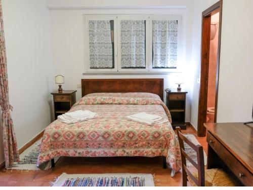 1 dormitorio con 1 cama, 2 mesas y una ventana en Agriturismo Tognoloni, en Gubbio