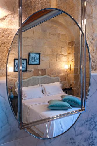 a bedroom with a large mirror over a bed at Lulu Boutique Hotel in Żebbuġ