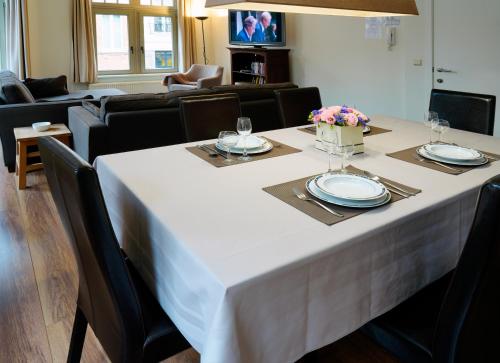 a dining room table with a white table cloth on it at Apartments Ypres in Ypres