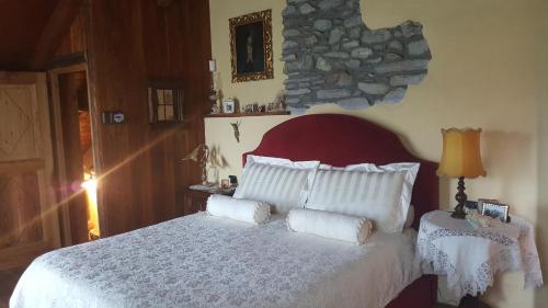 a bedroom with a large white bed with pillows at HOME SWEET HOME in Antey-Saint-André