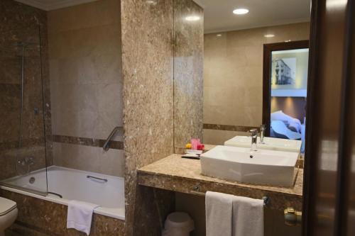 
a bathroom with a sink, toilet and bathtub at Gran Hotel España in Oviedo
