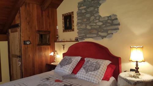 a bedroom with a bed and a stone wall at HOME SWEET HOME in Antey-Saint-André
