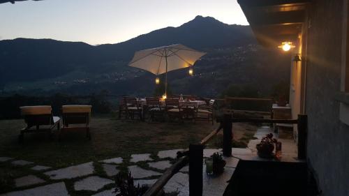 a patio with a table and an umbrella at HOME SWEET HOME in Antey-Saint-André