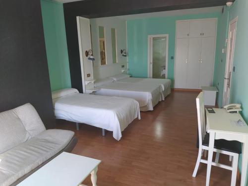 a room with two beds and a couch and a table at Hotel Aro'S in Casas Ibáñez