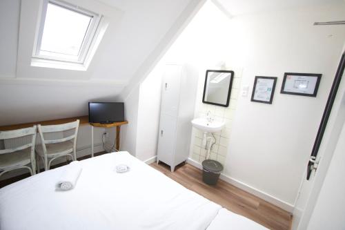 a white room with a white bed and a white wall at Hotel Hortus in Amsterdam