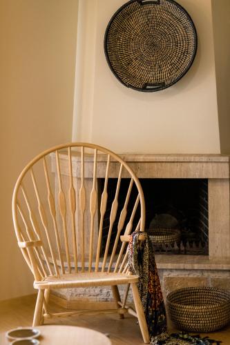 a wooden chair sitting in front of a fireplace at Anthemion Suites and Villas in Nafplio