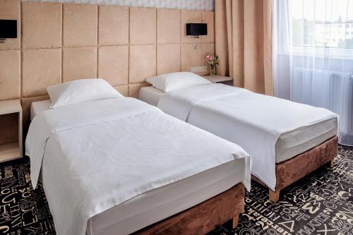 a hotel room with two beds and a window at Falenty Biznes i Wypoczynek in Raszyn