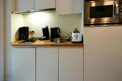 a kitchen counter with a sink and a microwave at Apartments Ypres in Ypres