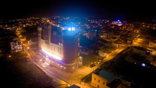 a large building with lights in a city at night at Chuan Cheng Castle in Magong