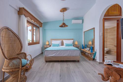 a bedroom with a bed and a chair and a mirror at Windmill Villa in Kalyves Poligirou