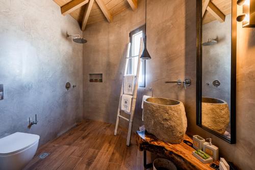 ein Badezimmer mit einem WC, einem Waschbecken und einem Spiegel in der Unterkunft Anthemion Suites and Villas in Nafplio