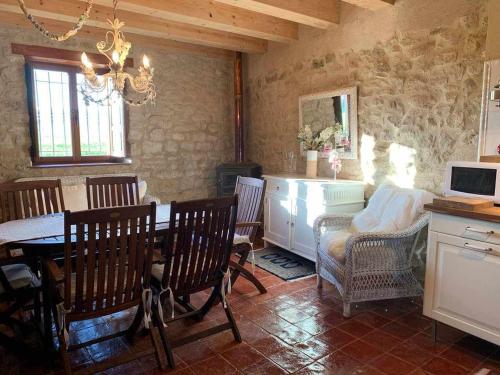 a kitchen with a table and chairs and a dining room at Casa Rural El Pajarcillo in Moriana