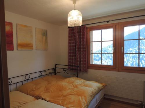 1 dormitorio con cama y ventana en Matti-Tinoll en Grimentz